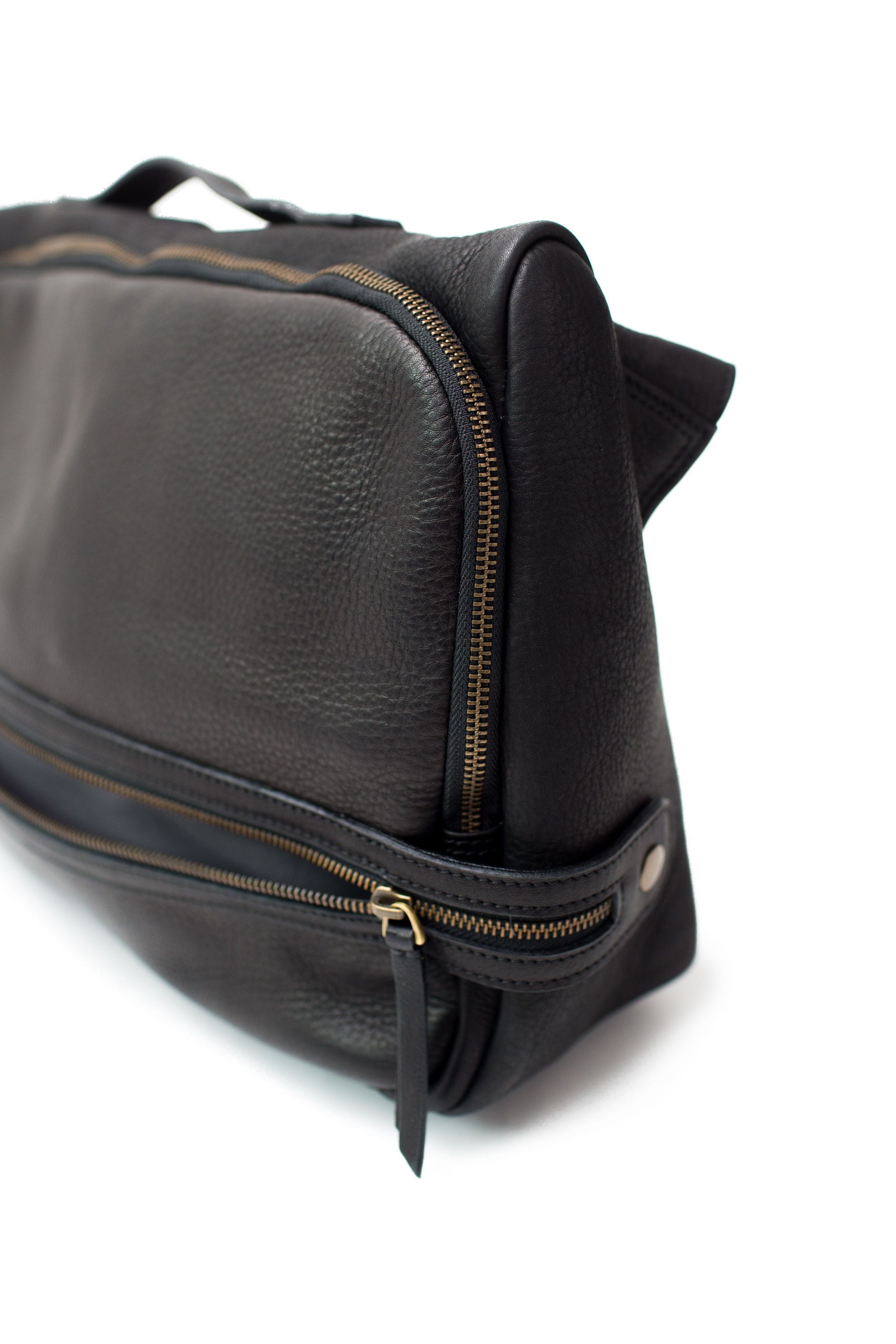 The exterior zipper pockets of the Rapinoe unisex messenger bag has plated brass hardware and YKK zippers.