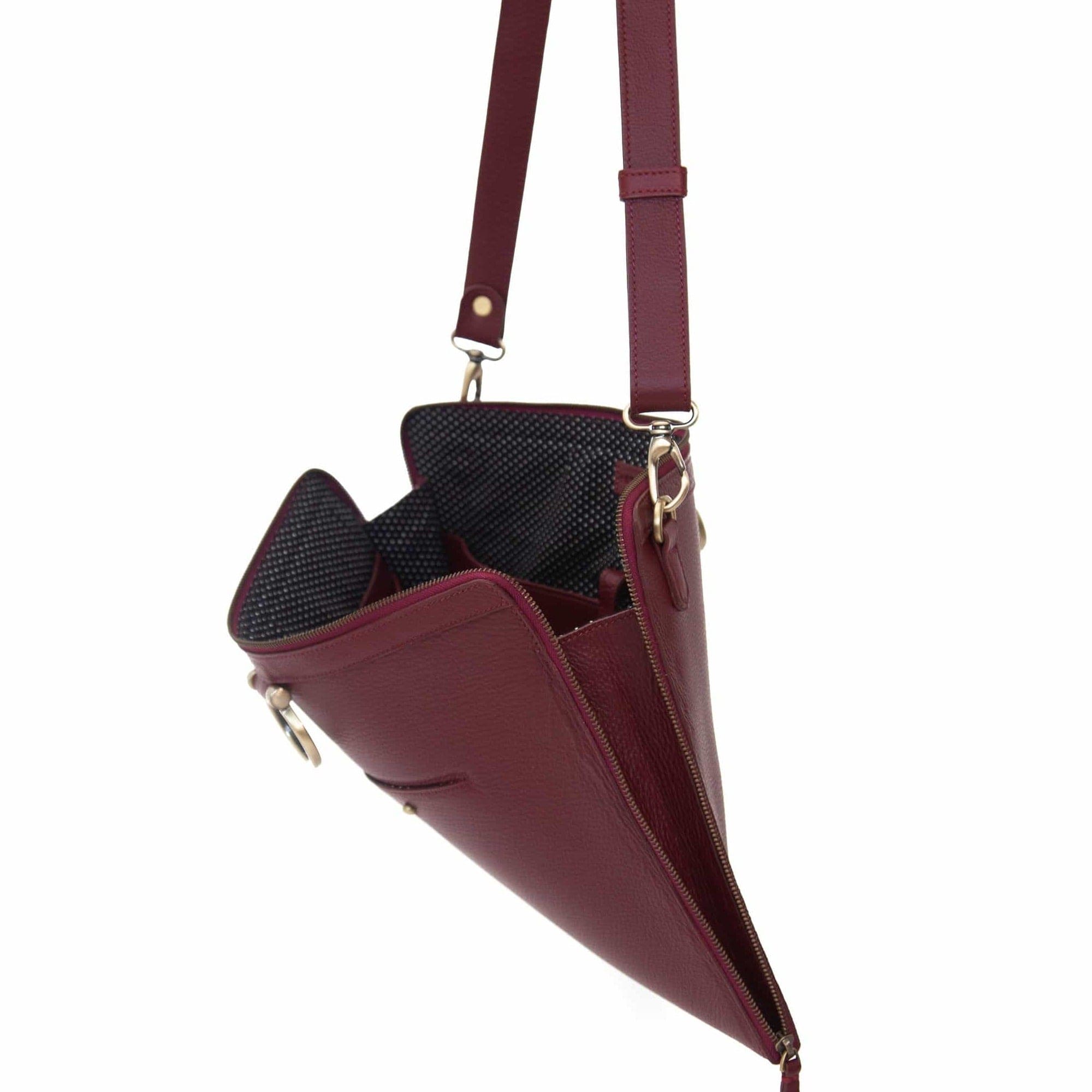 The M XL crossbody bag in deep red oil leather zips all the way around for a sleek, minimalist look.