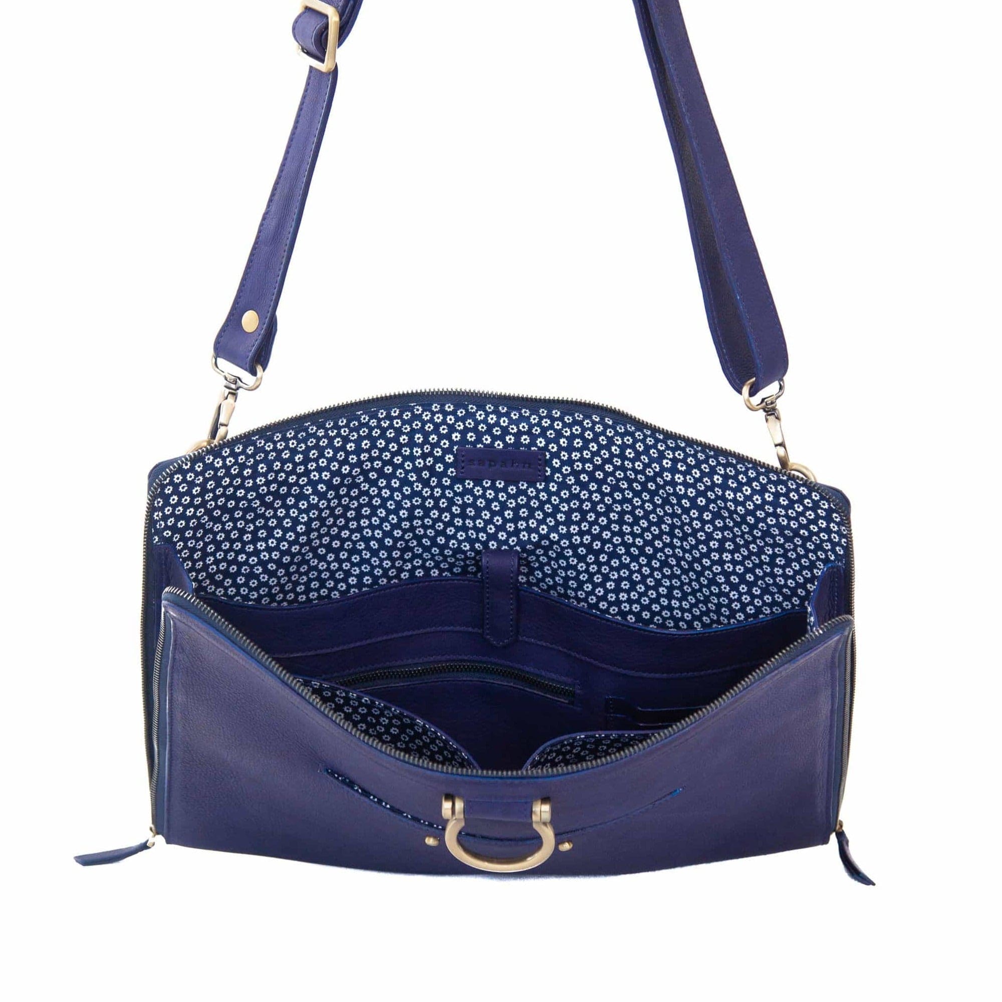 The M XL crossbody bag in indigo raw leather will hold your 15” laptop in a scratch-resistant interior sleeve.