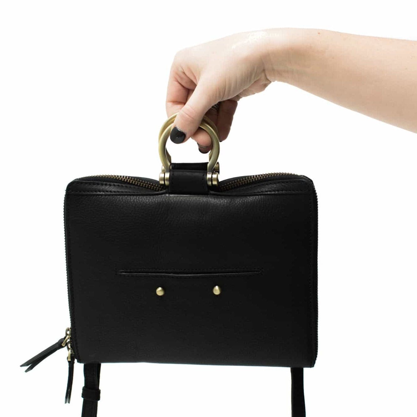 Carry the M mini crossbody bag in black raw leather by the Omega brass hardware.