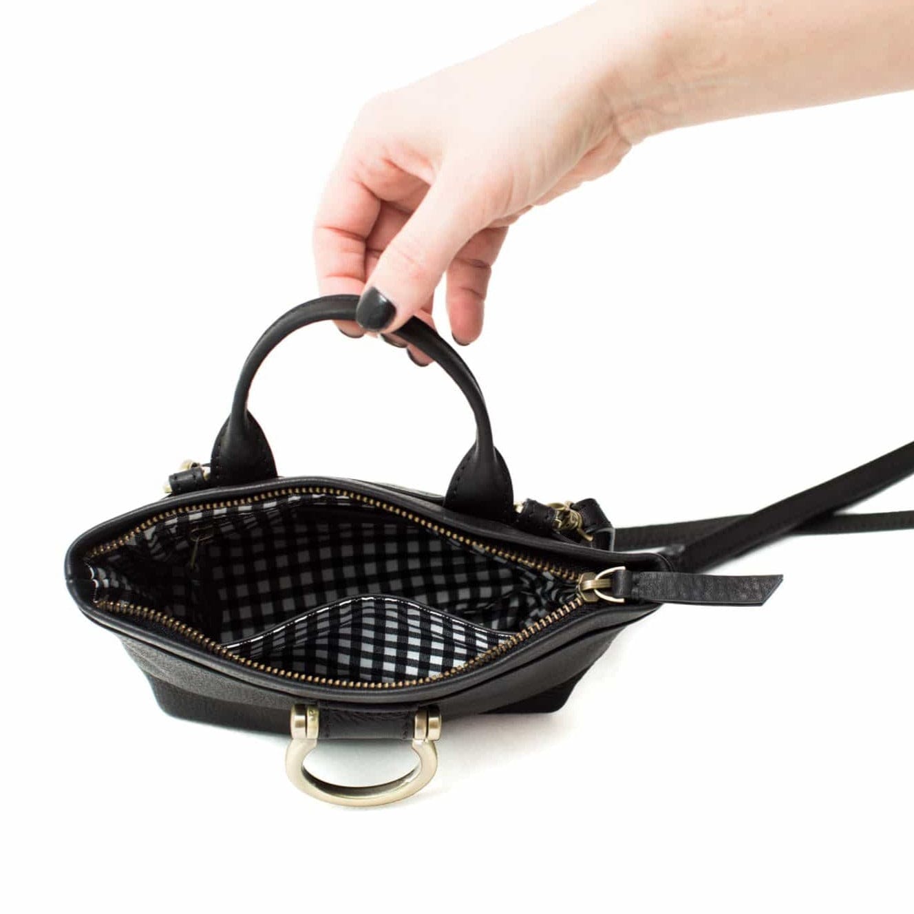 The Roger mini crossbody bag in black raw leather has two interior pockets.