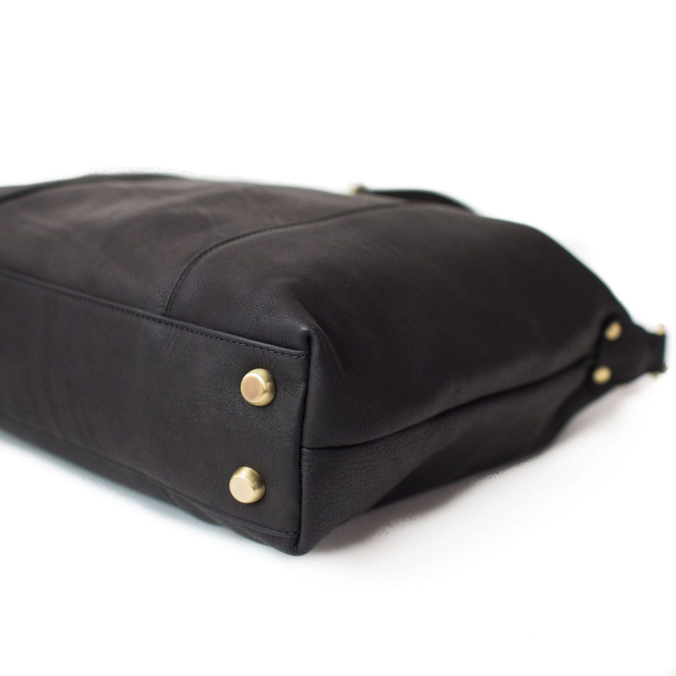 Linda Jean handbag in black raw leather has metal feet on the bottom to keep your bag protected.