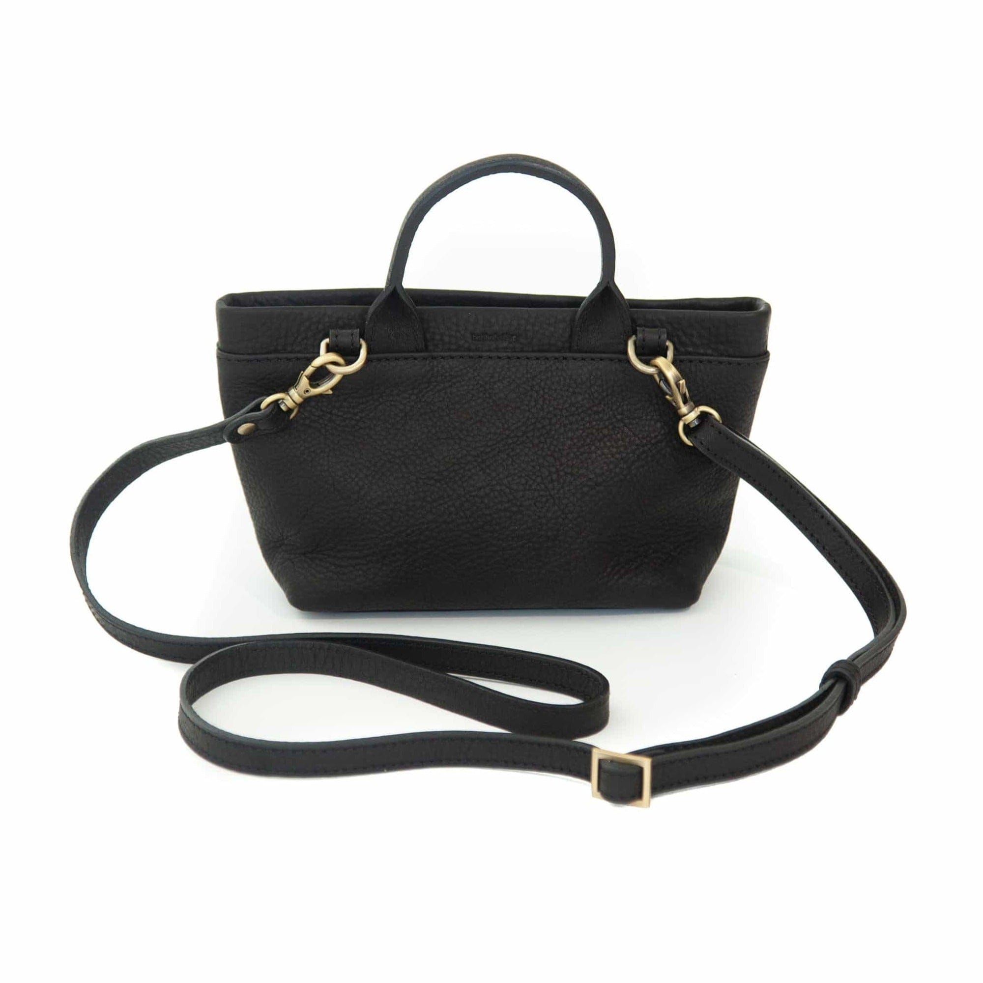 The Roger mini crossbody bag in black raw leather has an adjustable and removable strap.